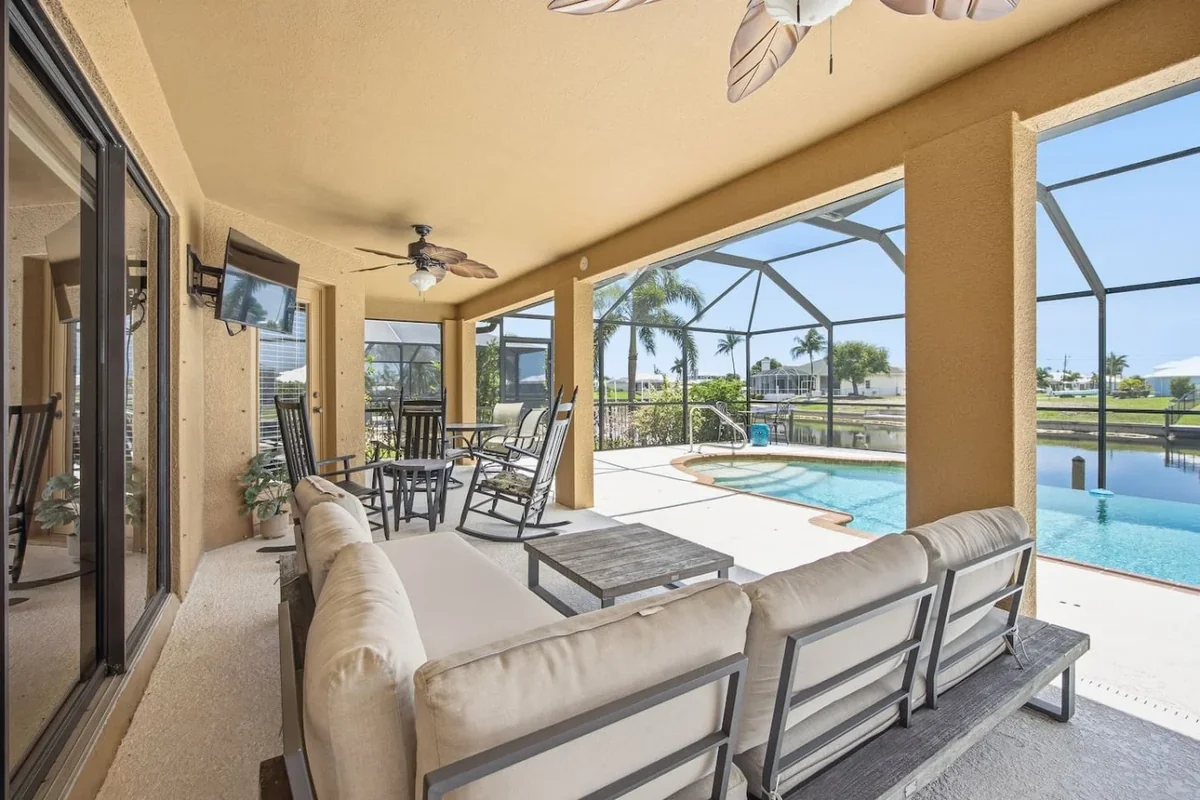 Covered outdoor seating beside the screened pool at a Cape Coral canal home